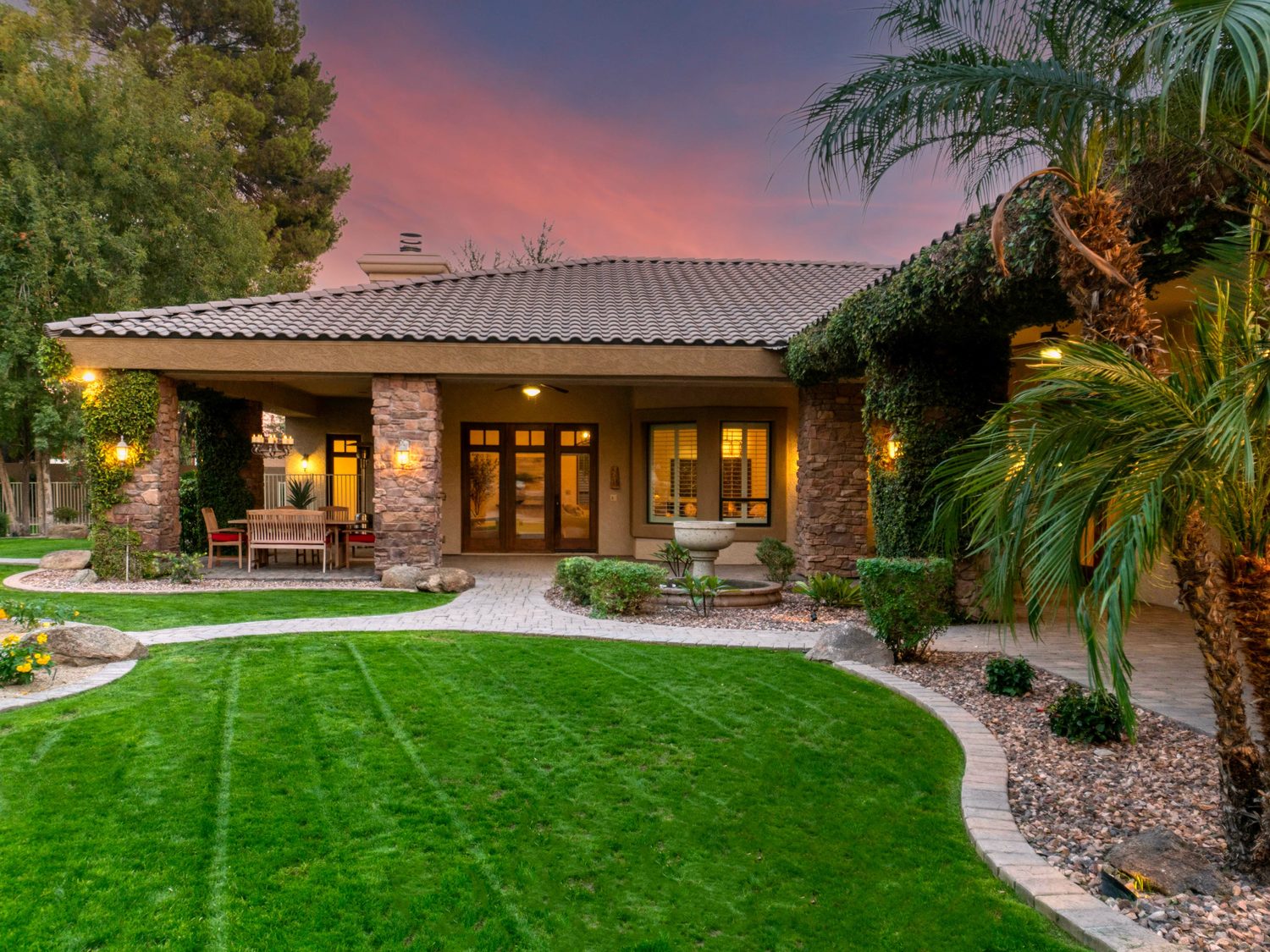 Muestra de estilo: villa contemporánea al atardecer con interiores cálidos encendidos.