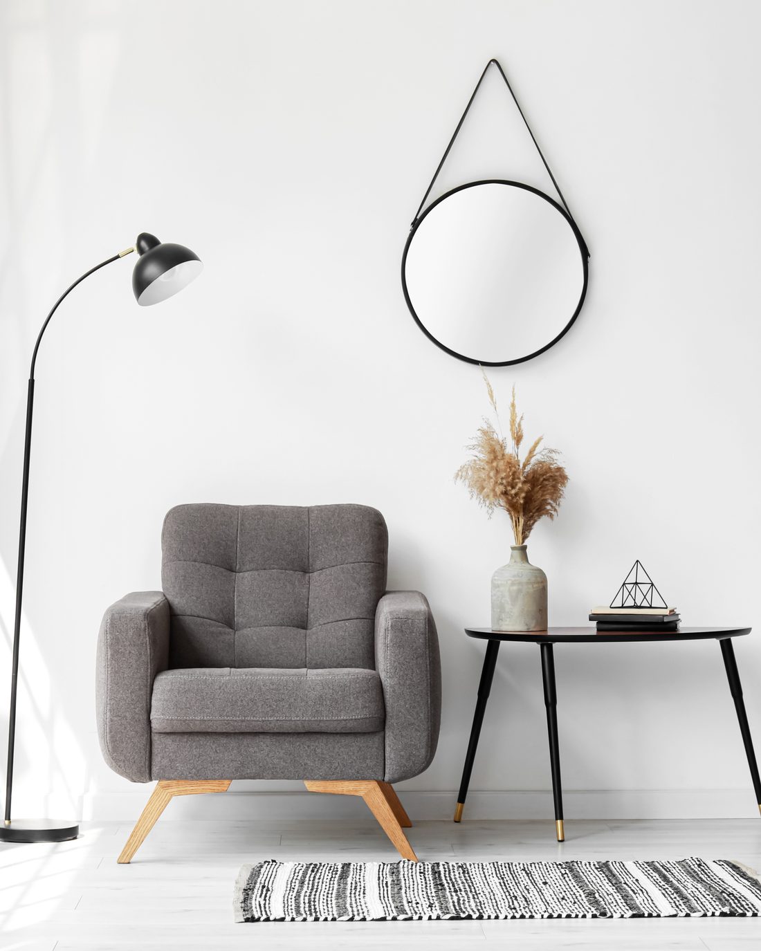 Muestra de estilo: rincón interior con butaca y espejo bañado por luz cálida.